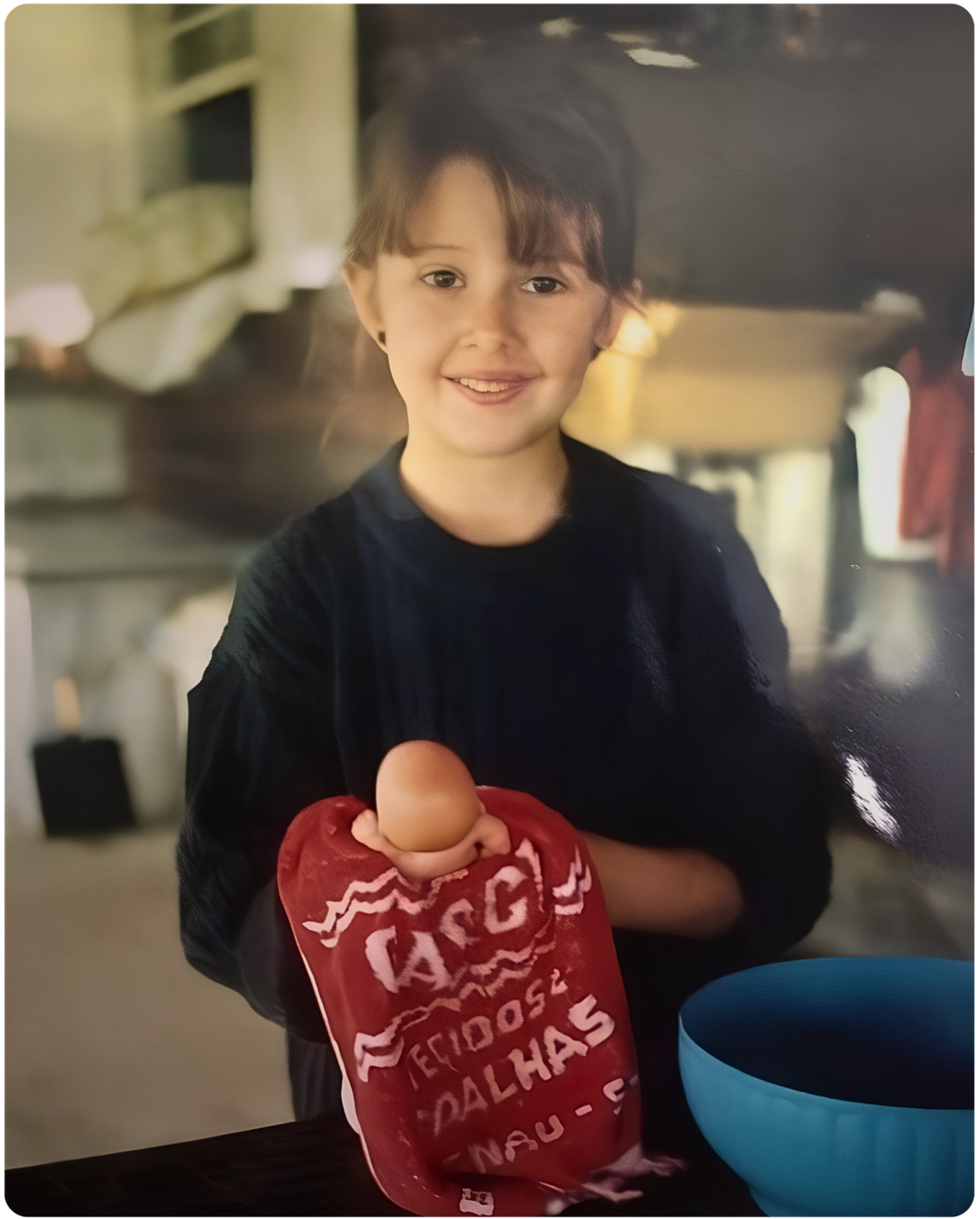 Foto de infância da Dra. Heloisa Vianello, pediatra em Alphaville, brincando de cuidar de bebê.